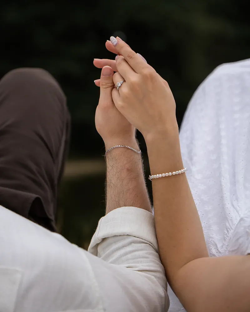Close-up of an engagement ring, hands held together