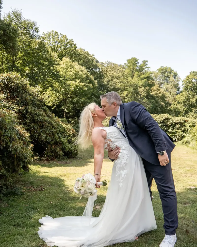 Couple kissing in a green setting, wedding photography by Hannah's Photoart
